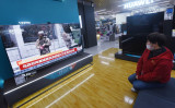 杭州のショッピングモールでウクライナ情勢に関する番組を見る買い物客。2月25日撮影（Photo by STR/AFP via Getty Images）