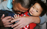 中国南西部の貴州省貴陽市にある貴陽児童福祉センターで、救助された息子を抱きしめて泣き崩れる男性（STR/AFP via Getty Images）